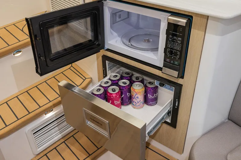 Slide: The Image of Interior of 2026 Hurricane SunDeck 3200 OB with microwave and beverage storage. - 16