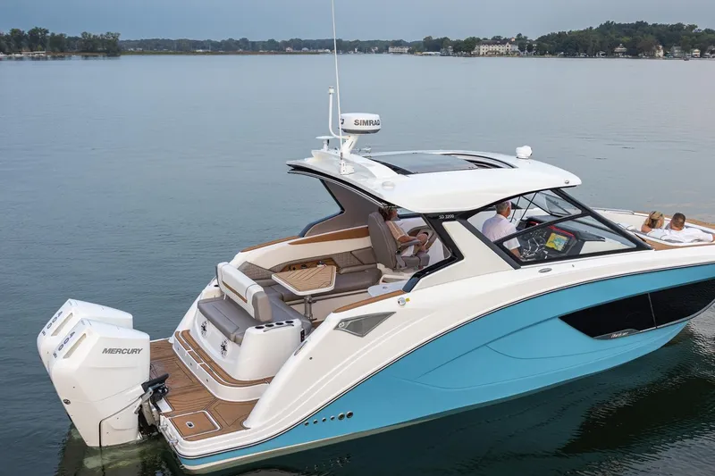 Slide: The Image of 2026 Hurricane SunDeck 3200 OB boat on calm lake, featuring sleek design and powerful Mercury engines. - 17