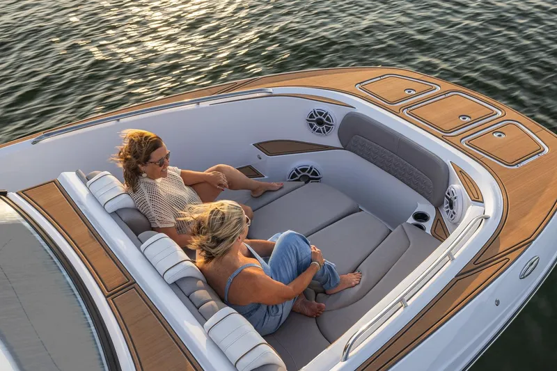 Slide: The Image of 2026 Hurricane SunDeck 3200 OB boat with two people relaxing on deck, enjoying the water. - 20