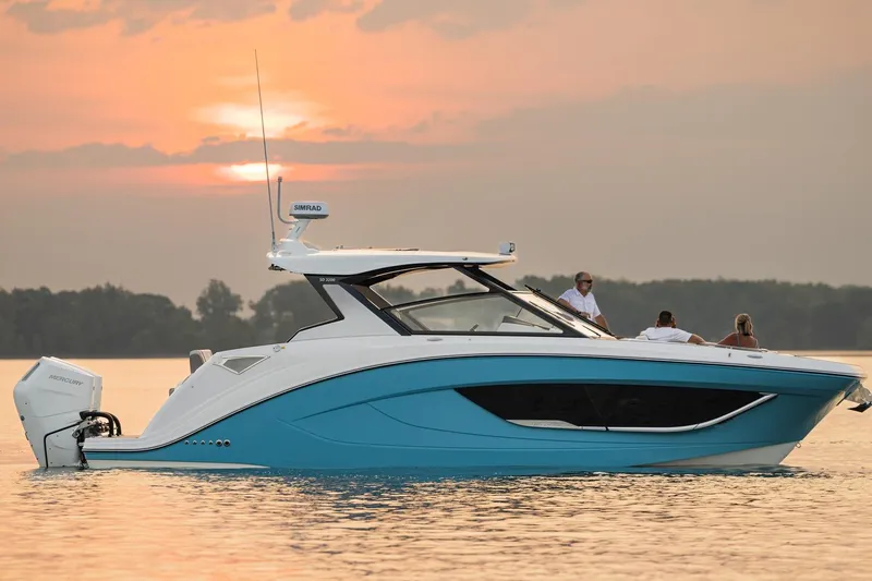 Slide: The Image of 2026 Hurricane SunDeck 3200 OB boat cruising at sunset on calm waters. - 23