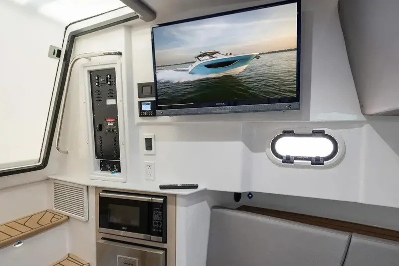 Slide: The Image of Manufacturer Provided Image: Interior of 2026 Hurricane SunDeck 3200 OB with TV, microwave, and control panel. - 6