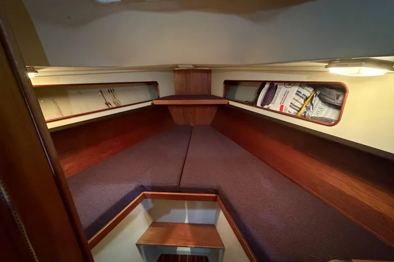 Slide: The Image of 1985 C&C 35 MK III sailboat cabin interior with wooden accents and storage shelves. - 17