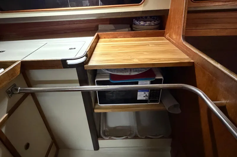 Slide: The Image of Compact kitchen area in a 1985 C&C 35 MK III sailboat with microwave and wooden countertop. - 22