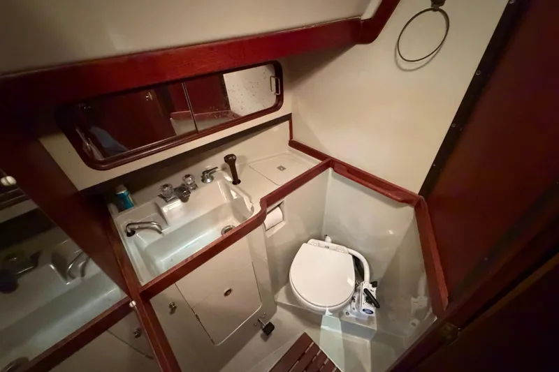 Slide: The Image of 1985 C&C 35 MK III yacht bathroom with sink, toilet, and wooden accents. - 26