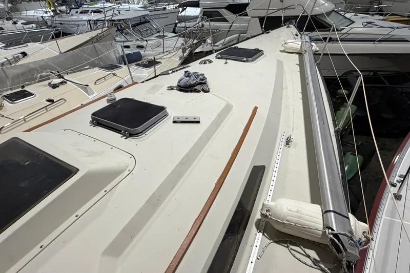 Slide: The Image of 1985 C&C 35 MK III sailboat deck view in marina, surrounded by other boats. - 35