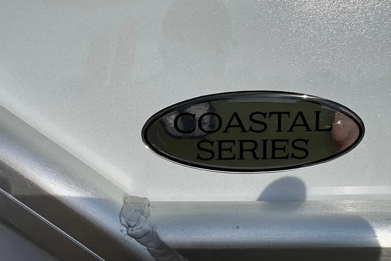 Slide: The Image of 2026 Bentley Pontoons 253 Elite Swingback DC, Coastal Series emblem detail. - 12