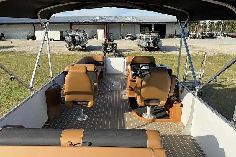 Slide: The Image of 2026 Bentley Pontoons 253 Elite Swingback DC interior with tan seating and steering console. - 49