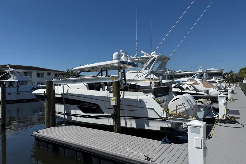 Slide: The Image of 2021 Jeanneau Leader 12.5 WA docked at marina under clear blue sky. - 10