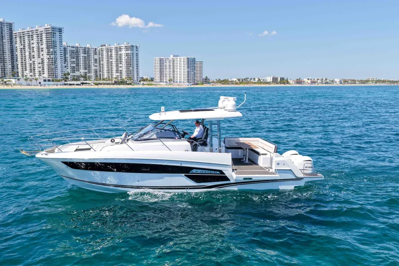 Slide: The Image of 2021 Jeanneau Leader 12.5 WA cruising on blue ocean near city skyline. - 2