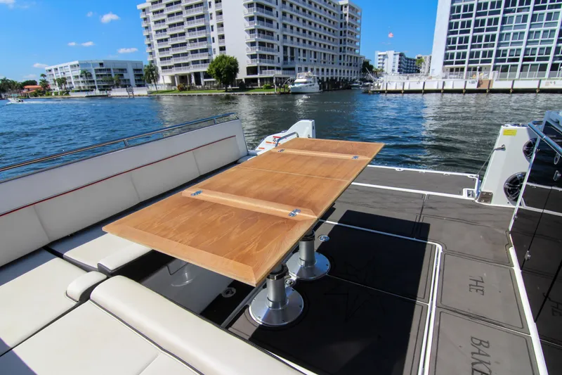 Slide: The Image of 2021 Jeanneau Leader 12.5 WA yacht with a wooden table, docked near waterfront buildings. - 31