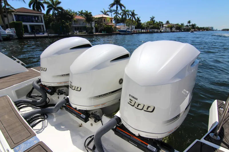 Slide: The Image of Triple Yamaha 300 engines on a 2021 Jeanneau Leader 12.5 WA boat, docked by waterfront homes. - 39