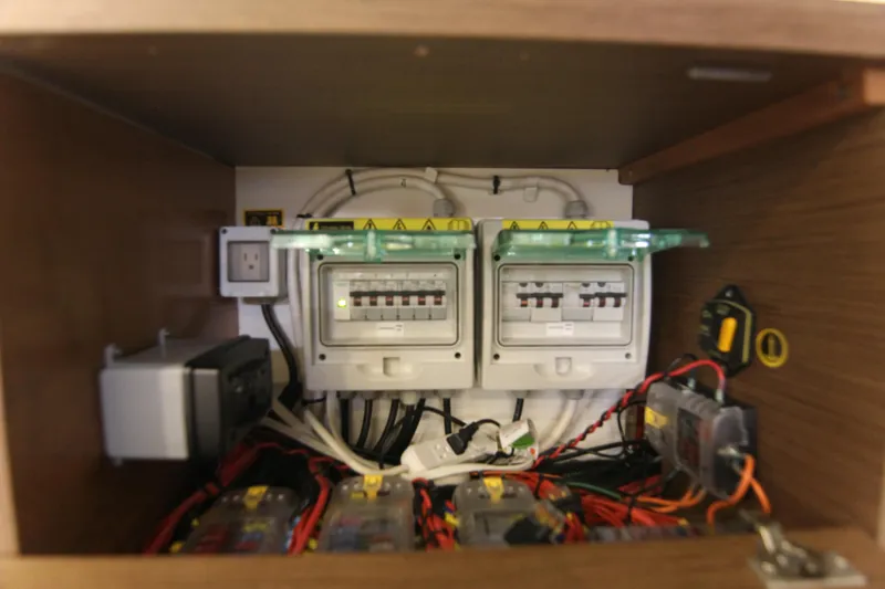 Slide: The Image of Electrical panel inside 2021 Jeanneau Leader 12.5 WA boat, showcasing wiring and circuit breakers. - 56