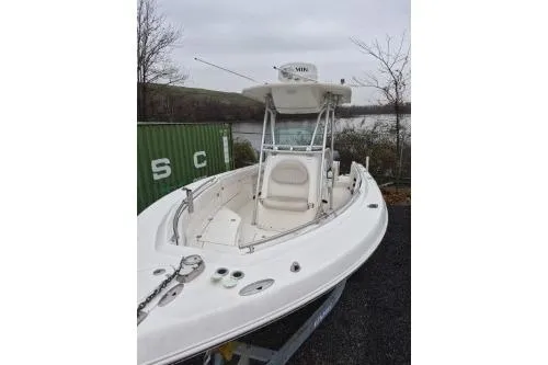Slide: The Image of 2005 Robalo R260 Center Console boat docked near a green container. - 3