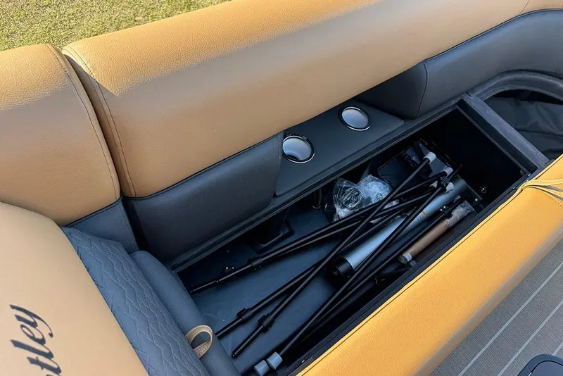 Slide: The Image of 2026 Bentley Pontoons Elite 253 Admiral storage compartment with tan and black seating. - 24