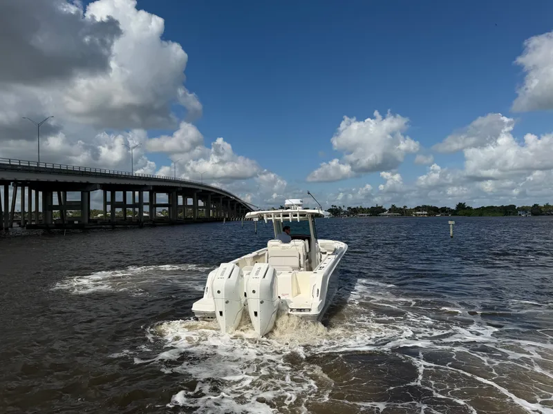Slide: The Image of A 2026 Boston Whaler 330 Outrage navigates a river beneath a bridge. - 6