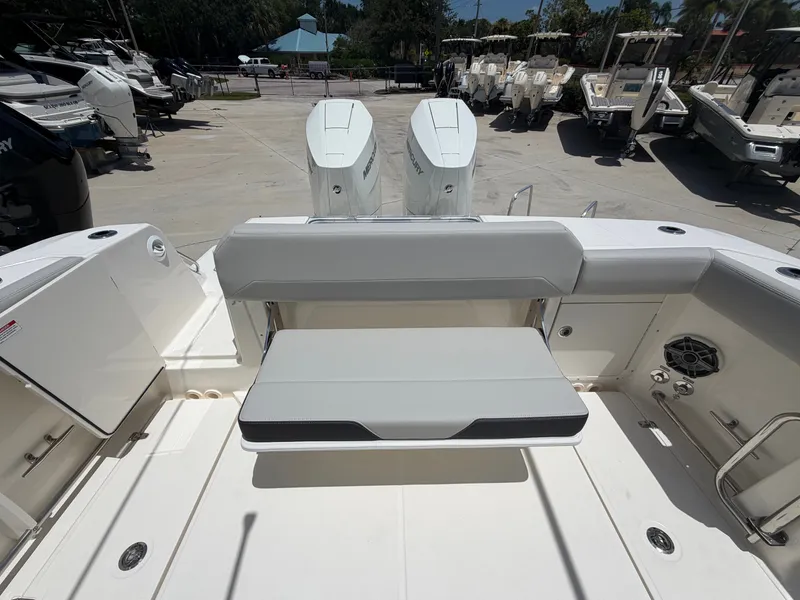 Slide: The Image of The image shows the stern of a Boston Whaler 330 Outrage with dual engines and a bench seat. - 19