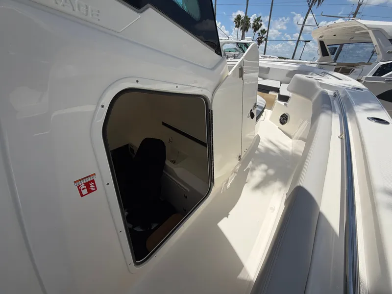 Slide: The Image of The 2026 Boston Whaler 330 Outrage features an open cabin door revealing the interior. - 38