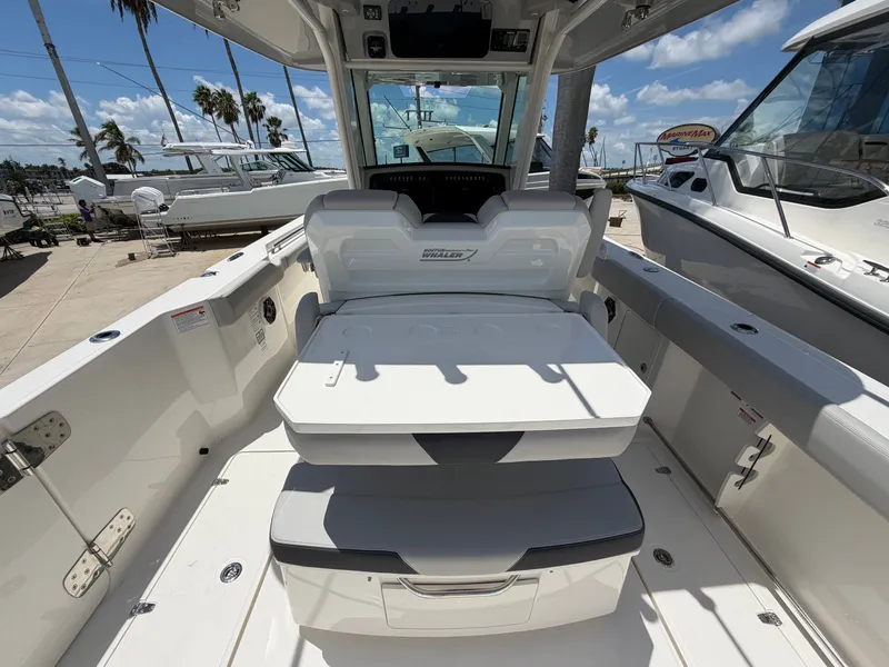 Slide: The Image of The image shows the cockpit of a 2026 Boston Whaler 330 Outrage with seating and storage. - 23