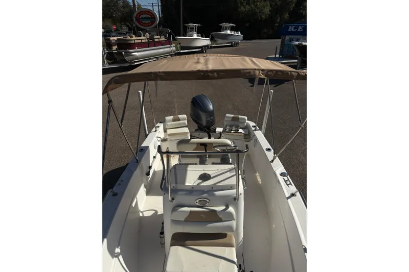 Slide: The Image of 2021 Edgewater 170CC boat with canopy and outboard motor in a marina setting. - 7