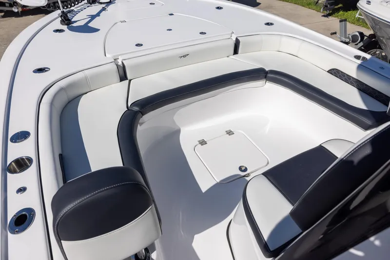 Slide: The Image of 2025 Tidewater 2500 Carolina Bay boat interior with cushioned seating and storage hatch. - 13