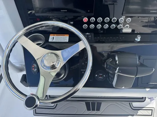 Slide: The Image of 2026 Wellcraft Fisherman 243 XB helm with steering wheel and controls. - 14