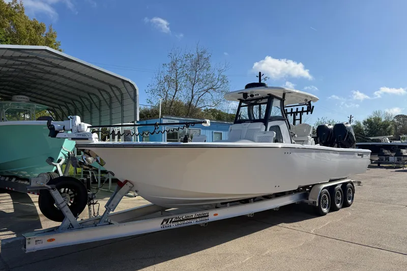 The Image of 2026 Tidewater 3100 Carolina Bay boat on trailer, parked outdoors under clear sky. - 1