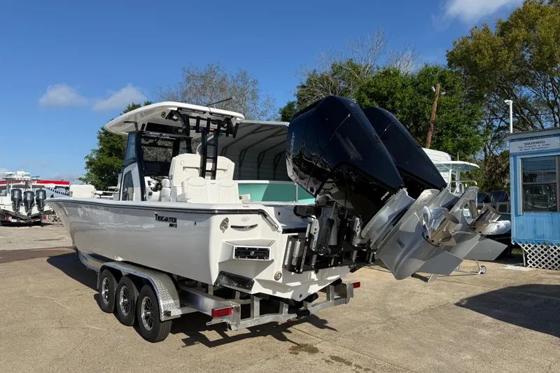 Slide: The Image of 2026 Tidewater 3100 Carolina Bay boat with dual outboard motors on a trailer. - 3
