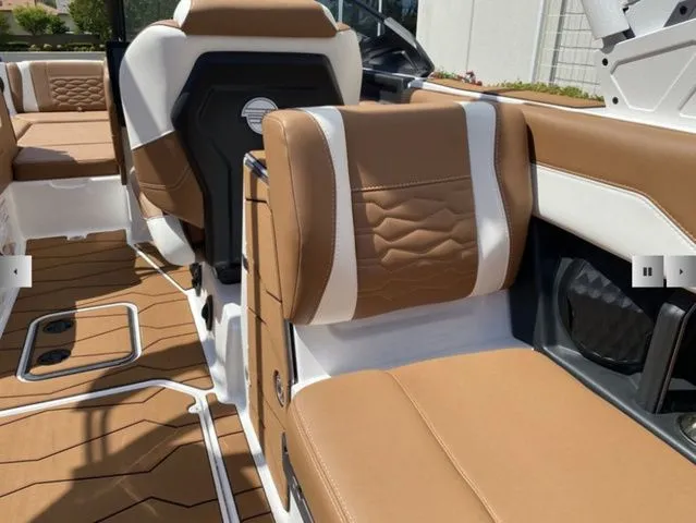 Slide: The Image of Interior of 2025 Malibu Wakesetter 24 MXZ with brown and white seating. - 18