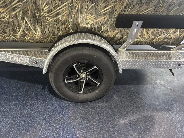 Slide: The Image of Thor Boats 1900 Lake Hammer trailer with camouflage pattern and black wheel. - 19