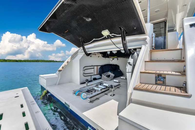 Slide: The Image of Astondoa 72 GLX 2013 yacht with open storage compartment, docked by clear blue water. - 25
