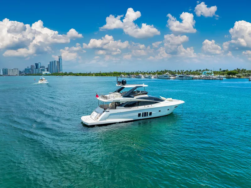 Slide: The Image of Astondoa 72 GLX yacht cruising on blue waters, 2013 model, with city skyline in background. - 3