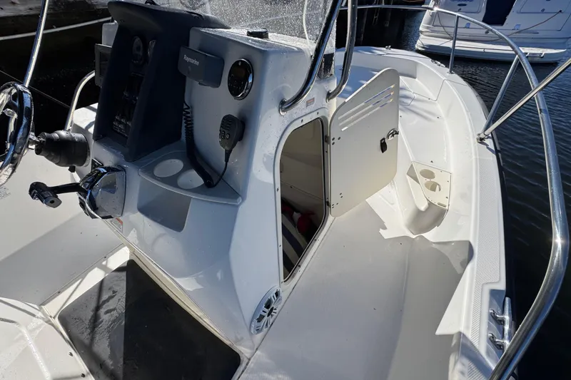 Slide: The Image of 2012 Boston Whaler 200 Dauntless boat interior with steering console and open storage compartment. - 12