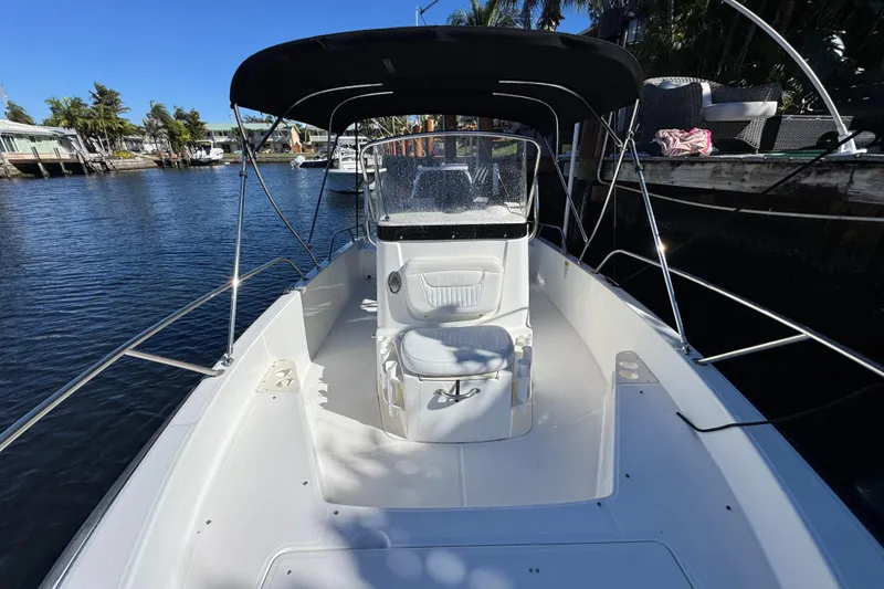 Slide: The Image of 2012 Boston Whaler 200 Dauntless boat docked on a sunny day, featuring a sleek design. - 13