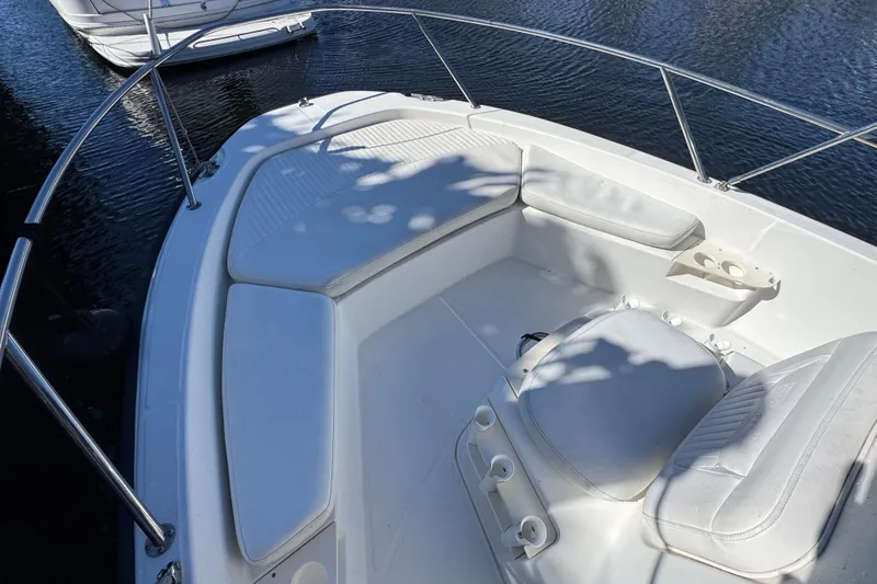 Slide: The Image of 2012 Boston Whaler 200 Dauntless boat interior with cushioned seating and cup holders. - 15