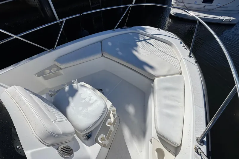 Slide: The Image of 2012 Boston Whaler 200 Dauntless boat interior with cushioned seating and stainless steel railings. - 16