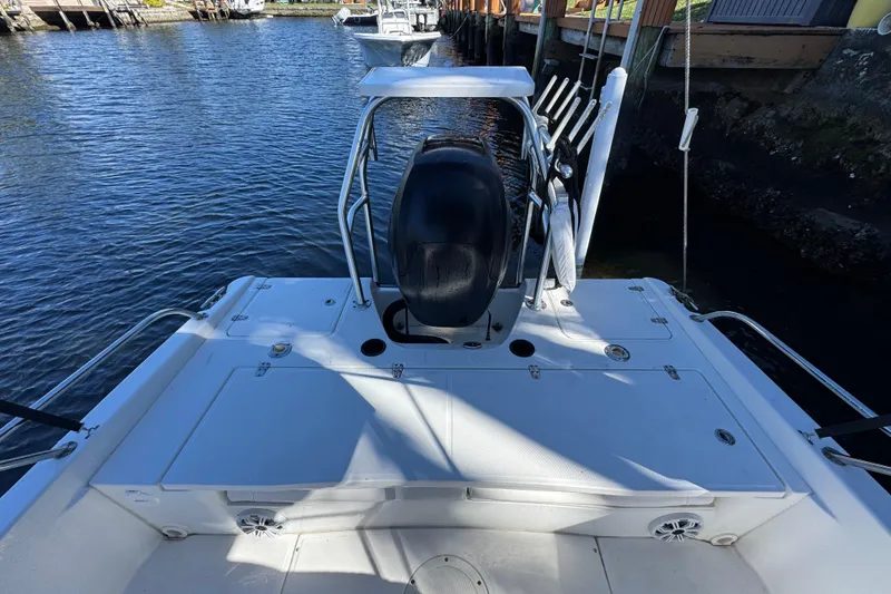 Slide: The Image of 2012 Boston Whaler 200 Dauntless boat deck with seating and rod holders, docked by the water. - 3