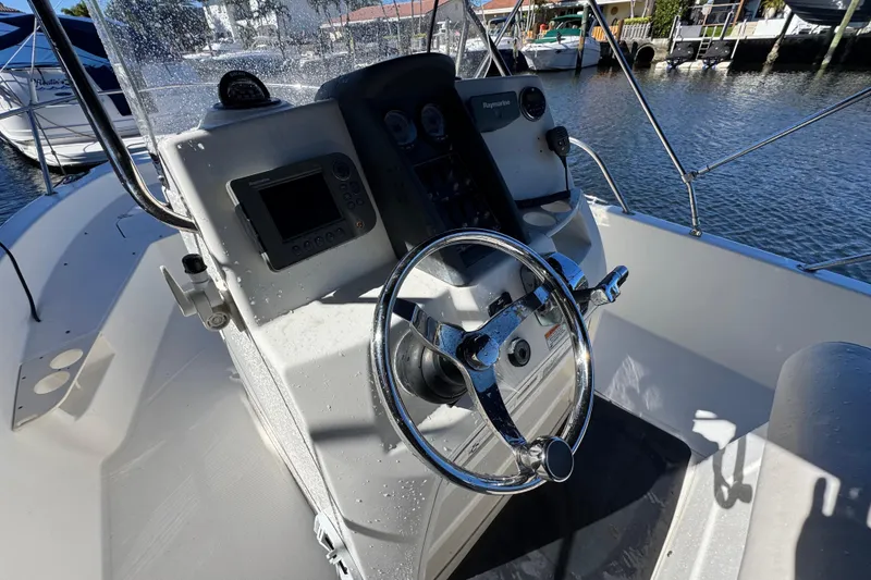 Slide: The Image of 2012 Boston Whaler 200 Dauntless boat console with steering wheel and navigation equipment. - 9