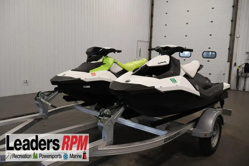 The Image of 2023 Sea-Doo Spark 3up jet skis on trailer in indoor showroom. - 1