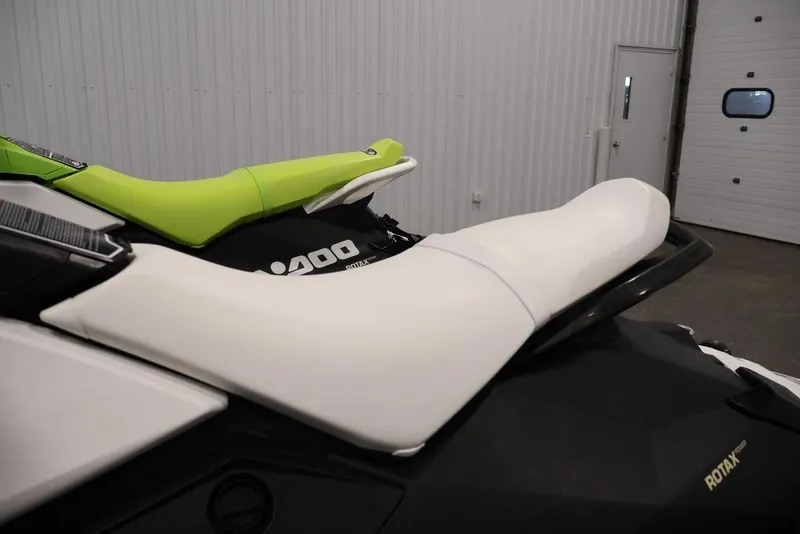 Slide: The Image of 2023 Sea-Doo Spark 3up jet ski with green and white seats in a garage setting. - 11
