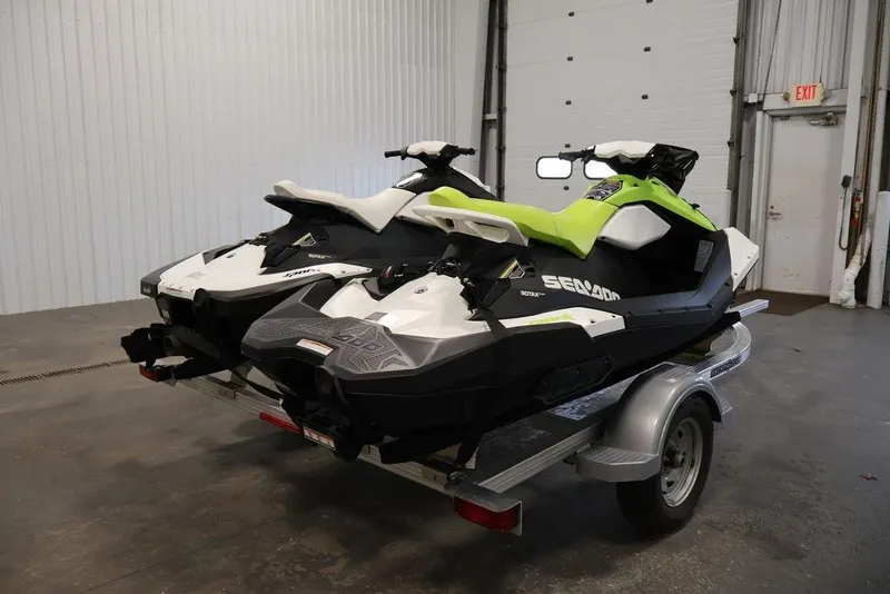 Slide: The Image of 2023 Sea-Doo Spark 3up jet skis on trailer in indoor garage setting. - 6
