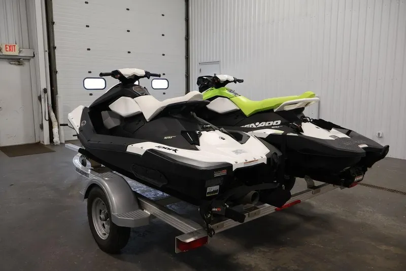 Slide: The Image of 2023 Sea-Doo Spark 3up jet skis on trailer in garage setting. - 8
