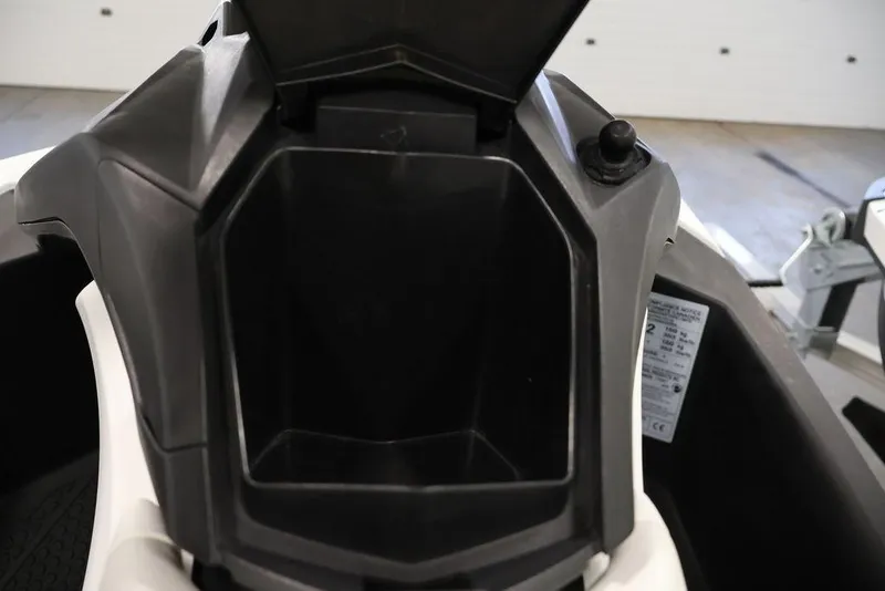 Slide: The Image of 2023 Sea-Doo Spark 3up storage compartment, open and empty, in a garage setting. - 9