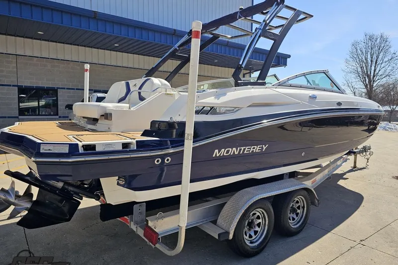 Slide: The Image of 2013 Monterey M3 Sport Boat on trailer, parked outdoors near a building. - 10