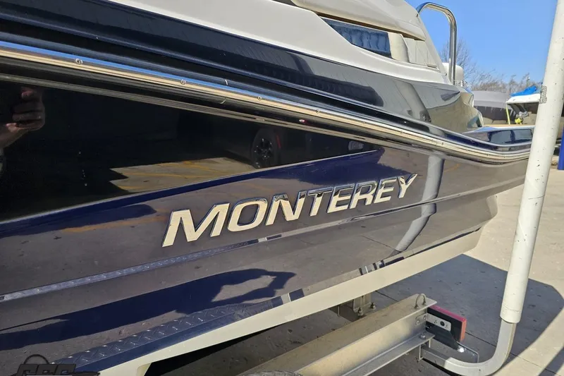 Slide: The Image of 2013 Monterey M3 Sport Boat side view with logo, parked on a trailer. - 21