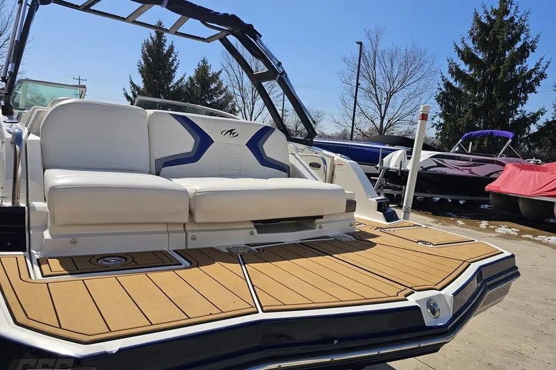 Slide: The Image of 2013 Monterey M3 Sport Boat with white seating and teak deck, parked outdoors. - 27