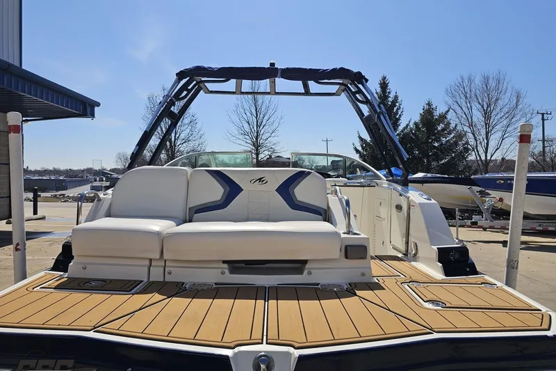 Slide: The Image of 2013 Monterey M3 Sport Boat with sleek seating and modern design in a marina setting. - 30