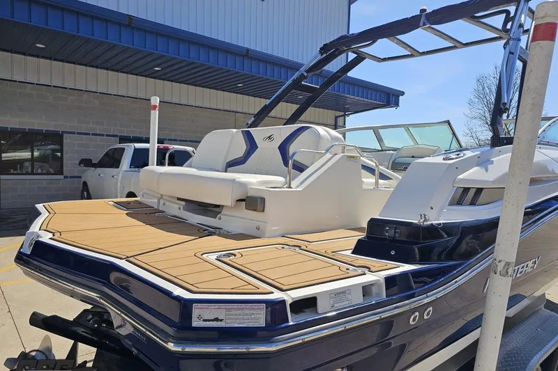 Slide: The Image of 2013 Monterey M3 Sport Boat with sleek design and spacious deck at a marina. - 31