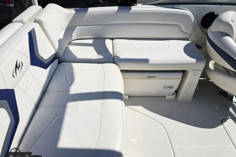 Slide: The Image of 2013 Monterey M3 Sport Boat interior with white cushioned seating and integrated storage. - 47