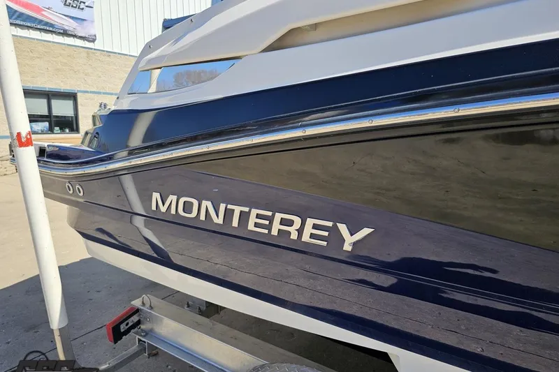 Slide: The Image of 2013 Monterey M3 Sport Boat side view with logo, parked on a trailer. - 6