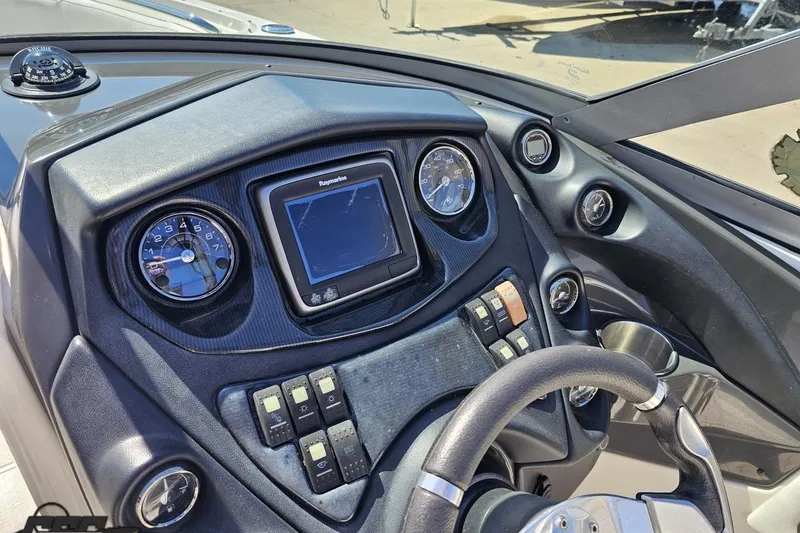 Slide: The Image of Dashboard of a 2013 Monterey M3 Sport Boat with steering wheel and navigation controls. - 62